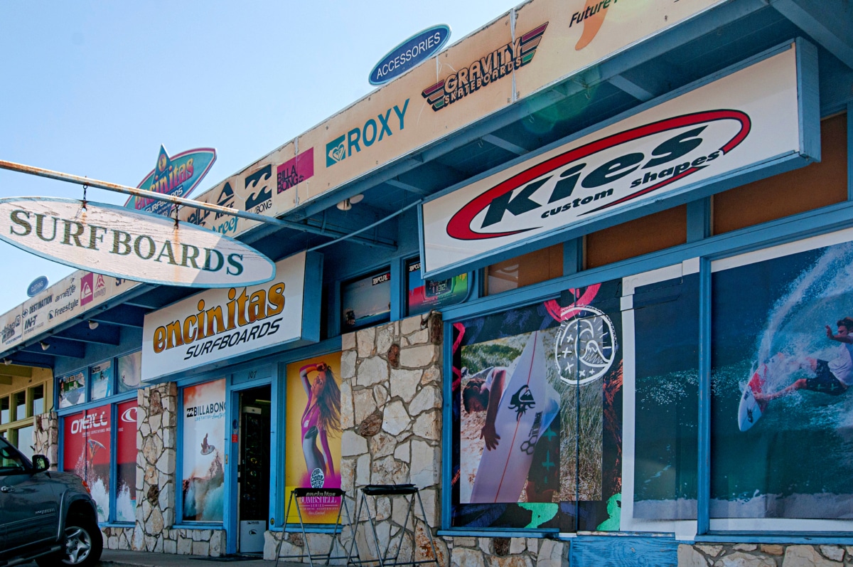 Local surf shops along Coast Highway in Encinitas with custom surfboards, brand signage, and a laid-back coastal streetscape