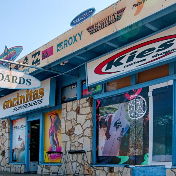 Local surf shops along Coast Highway in Encinitas with custom surfboards, brand signage, and a laid-back coastal streetscape