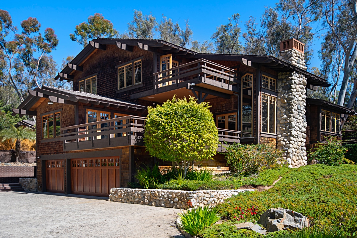 Wood and stone estate home in Rancho Santa Fe with balconies, natural materials, and architecture designed to blend into the landscape