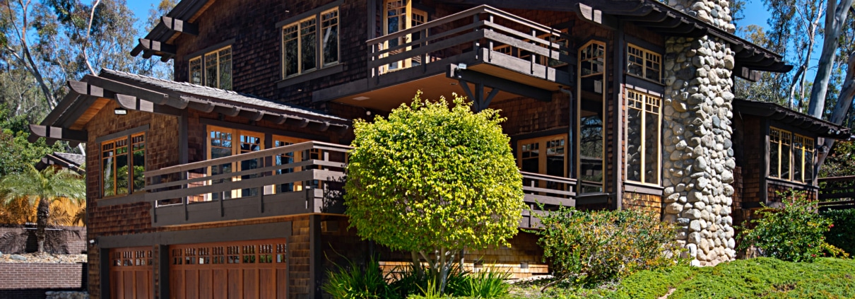Wood and stone estate home in Rancho Santa Fe with balconies, natural materials, and architecture designed to blend into the landscape