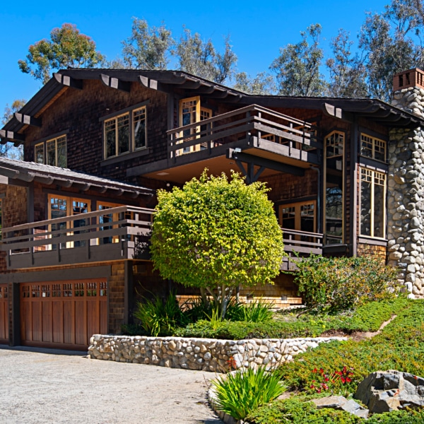 Wood and stone estate home in Rancho Santa Fe with balconies, natural materials, and architecture designed to blend into the landscape