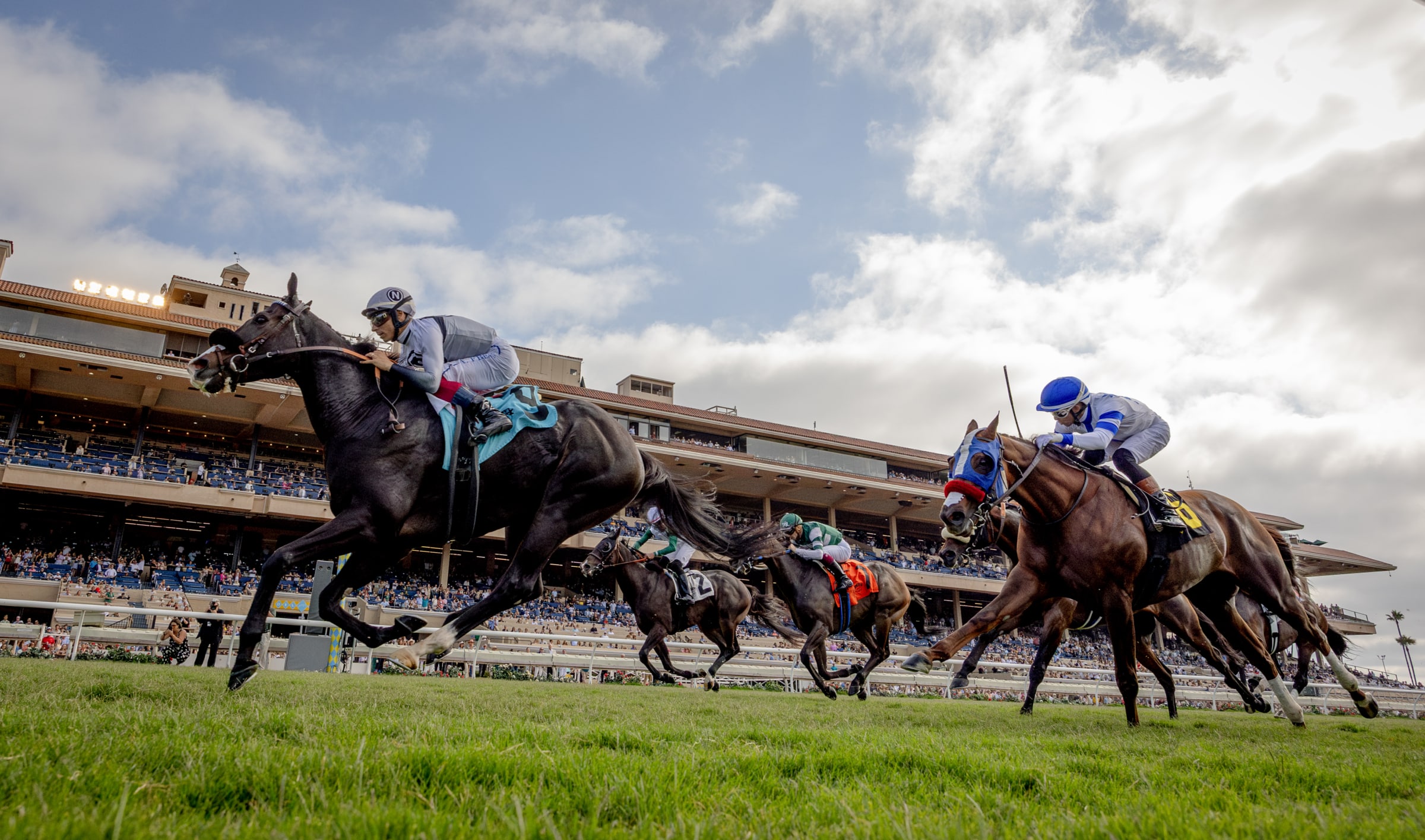The energy of the track, captured in motion. Thoroughbred horses racing past the grandstand at Del Mar Racetrack