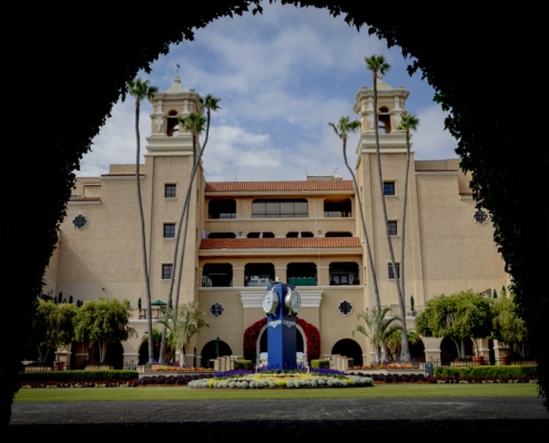 Framing the entrance to a timeless race day tradition. Del Mar Racetrack entrance framed by archway with clock tower and palm trees