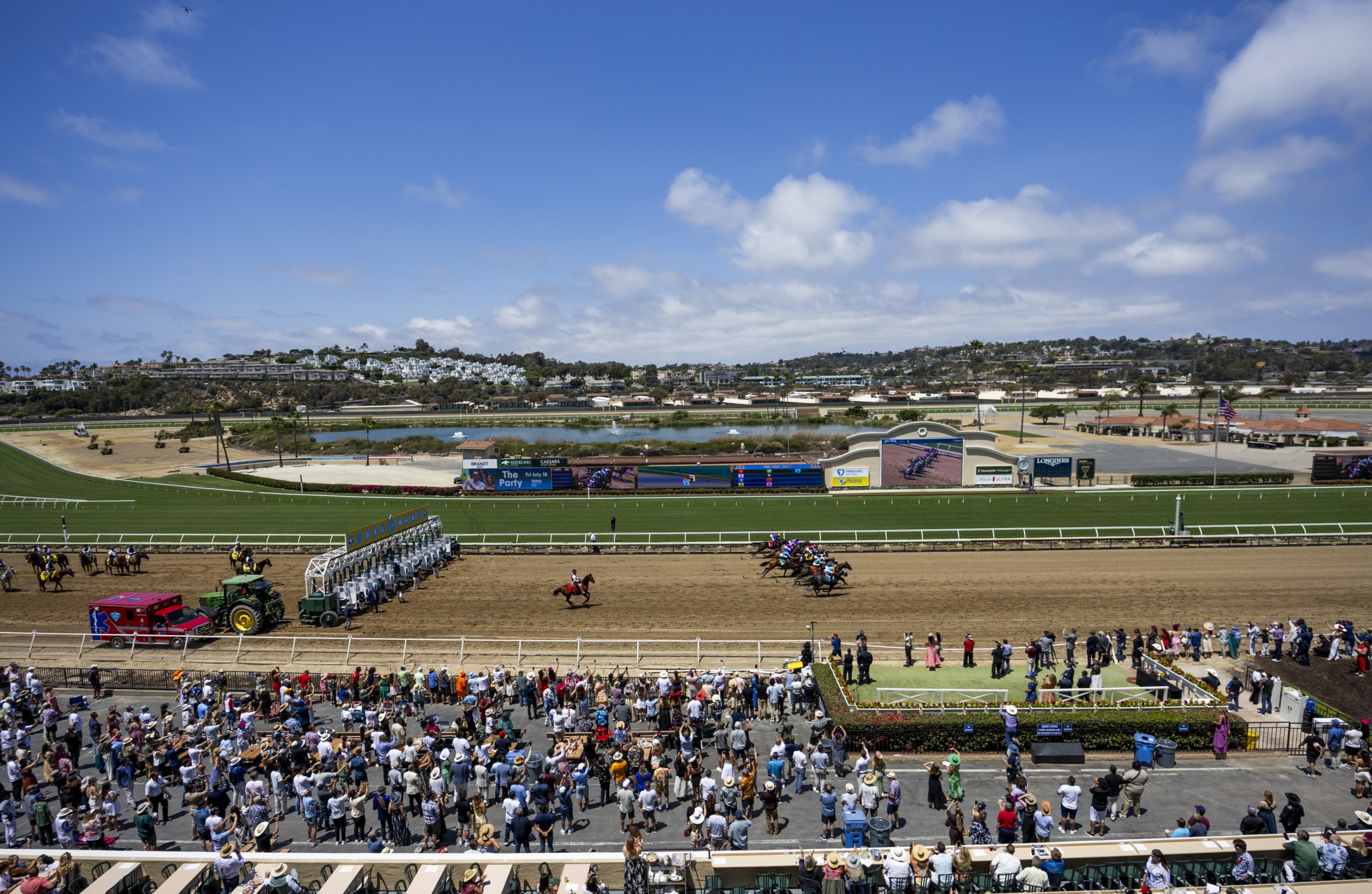 Where the turf meets the surf. Wide view of Del Mar Racetrack with horses racing and coastal landscape beyond