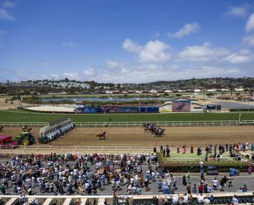 Where the turf meets the surf. Wide view of Del Mar Racetrack with horses racing and coastal landscape beyond