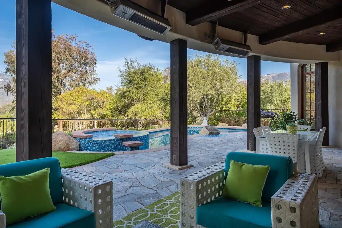 Indoor-Outdoor Living at The Bridges Rancho Santa Fe Covered patio with seating overlooking pool and spa at a single-level estate in The Bridges Rancho Santa Fe