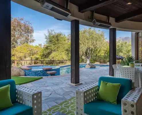 Indoor-Outdoor Living at The Bridges Rancho Santa Fe Covered patio with seating overlooking pool and spa at a single-level estate in The Bridges Rancho Santa Fe