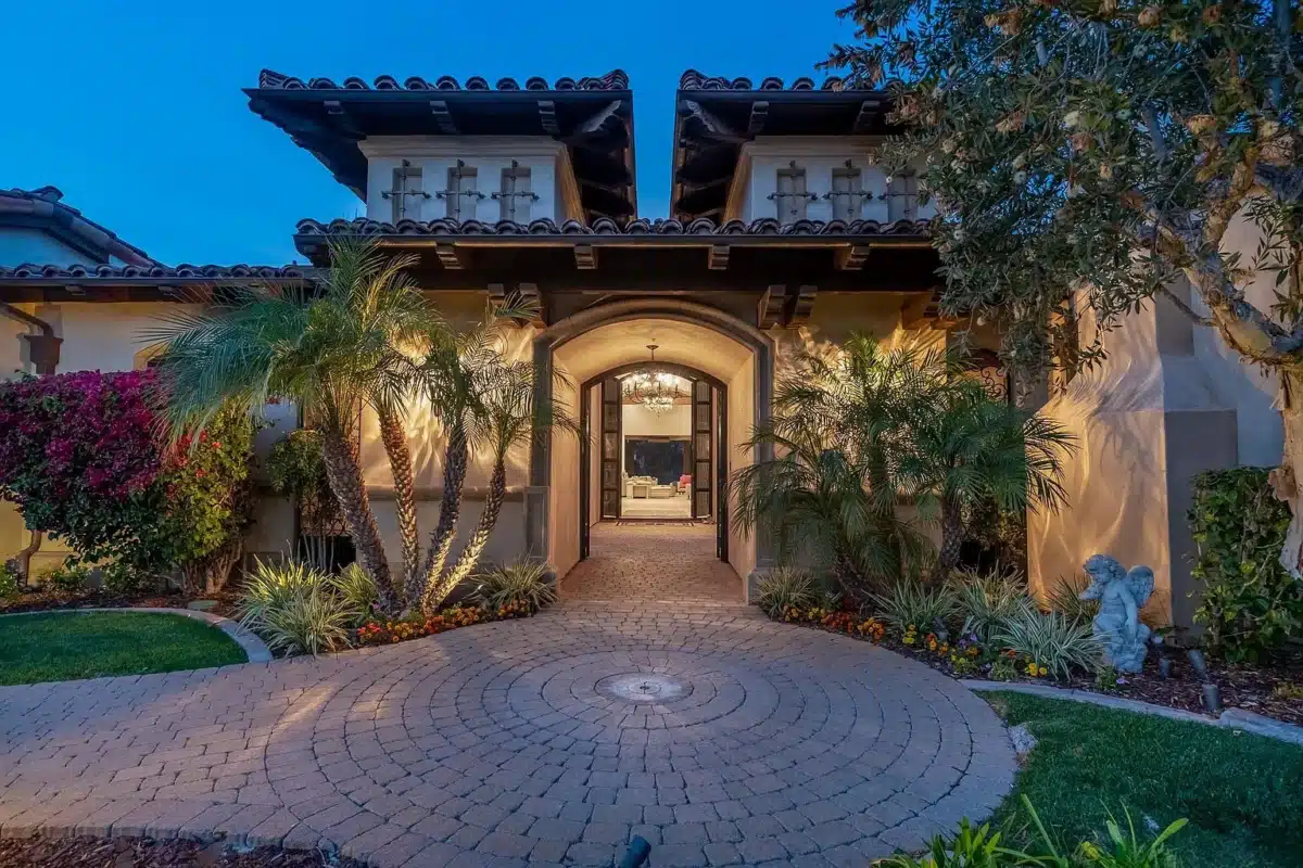 Arrival at a Bridges Rancho Santa Fe Estate Front entry of a luxury estate at The Bridges Rancho Santa Fe with arched doorway and evening lighting