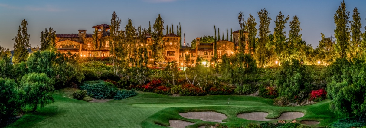Twilight view of The Bridges golf course and estate homes in Rancho Santa Fe with rolling fairways and illuminated residences.